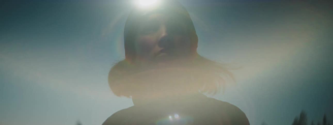 A woman lost in the forest with a flashlight on her head during dusk