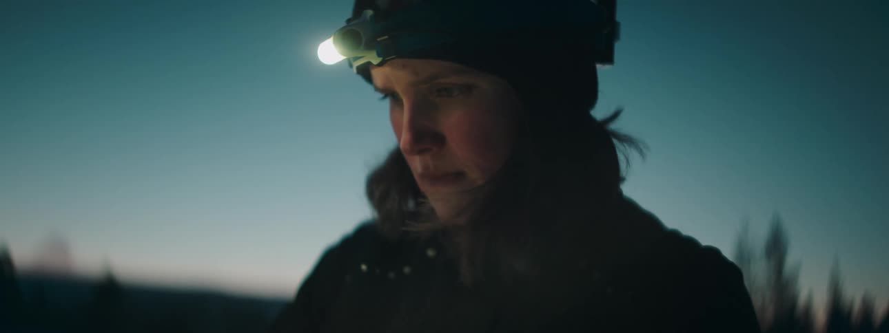 Closeup of a womans face with a flashlight at dusk
