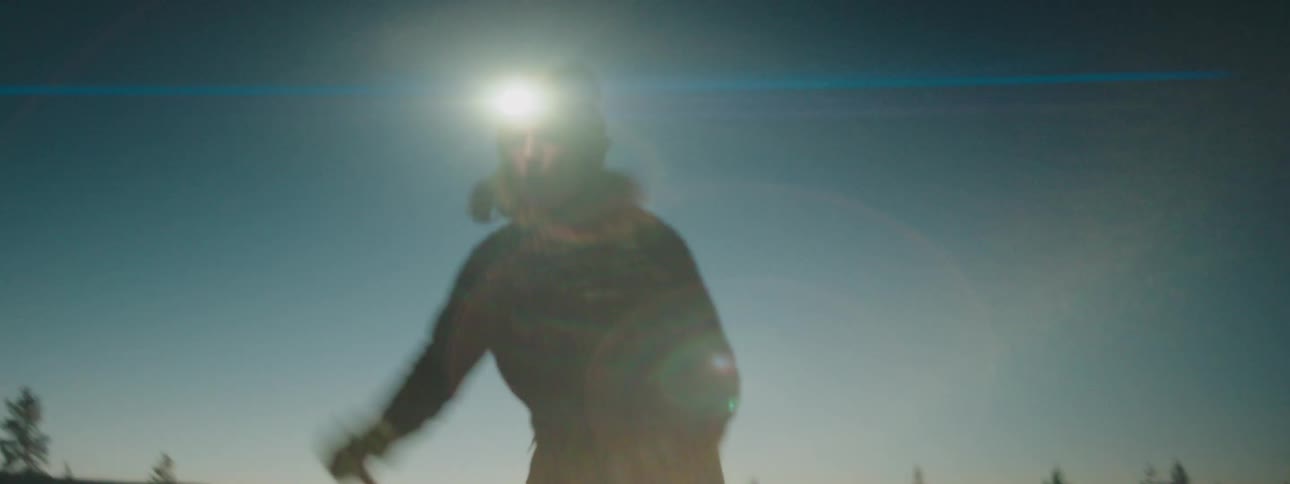 A woman wearing a headlamp at night