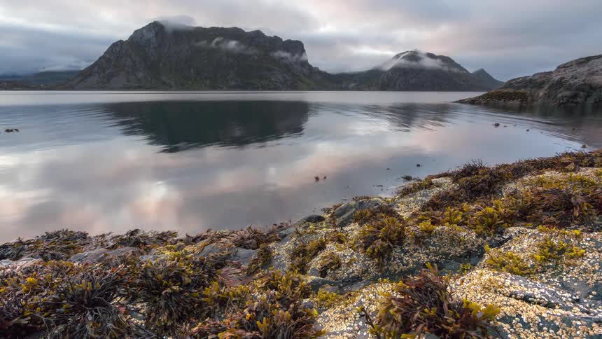 The lake water splashes against the mountain shore