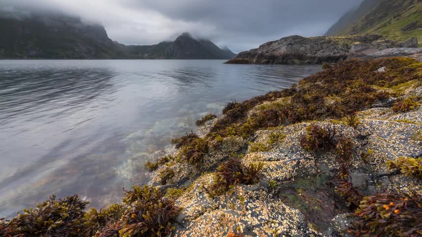 Timelapse landscape with a reflective lake and mountains around