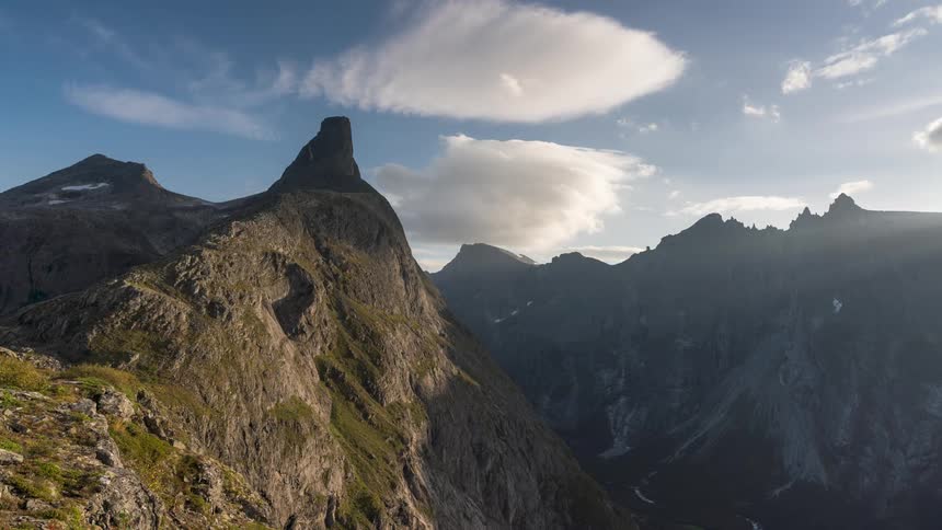 A time lapse view of mountains under a cloudy sky at dawn