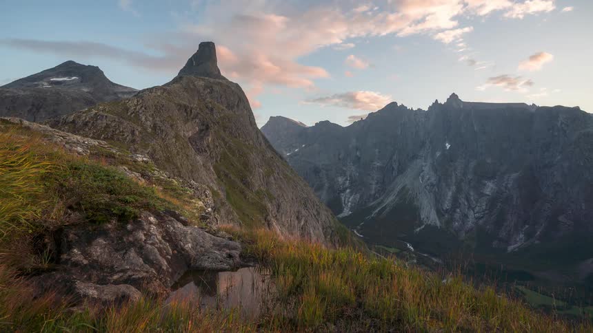 A view of mountains under a cloudy sky at dusk
