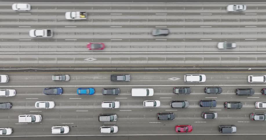 Top down view of ten lane highway with light traffic in one direction and heavy traffic in the other