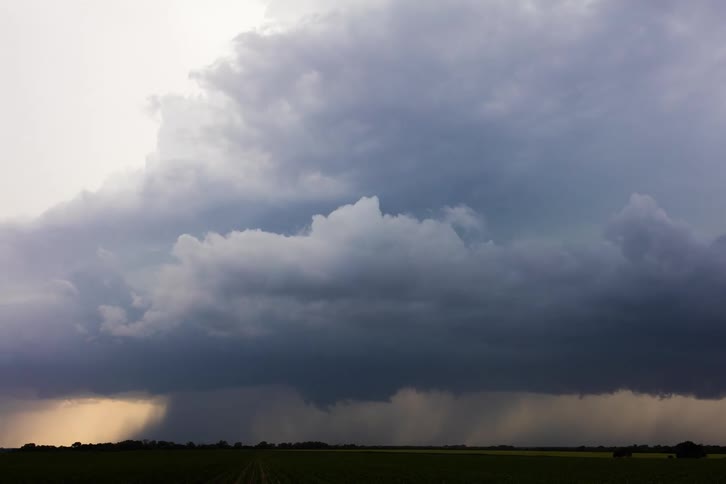 Dark storm clouds move across the sky as rain pours down