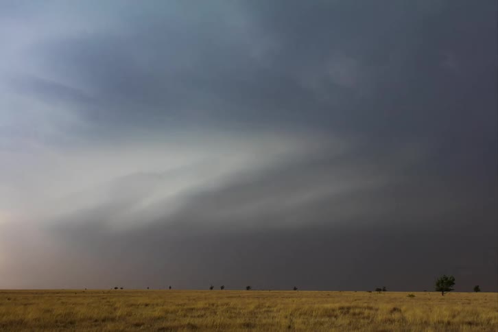 A large storm forms over a grassy area