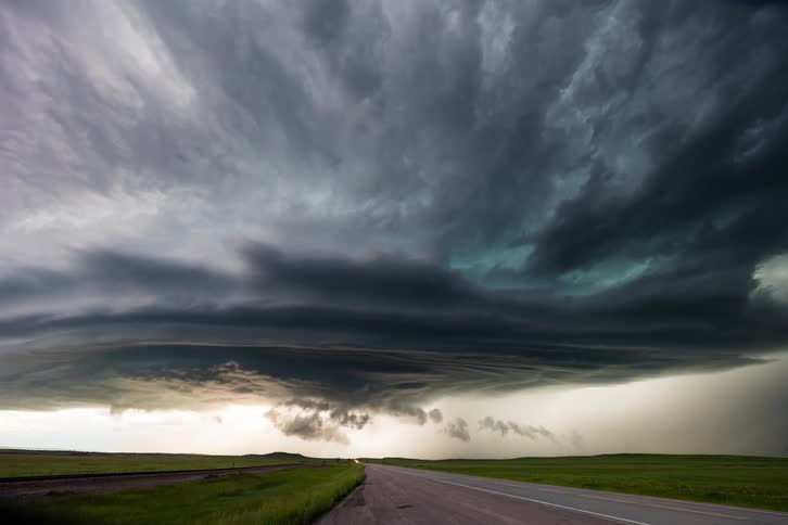 Dark storm clouds move over traffic on the road