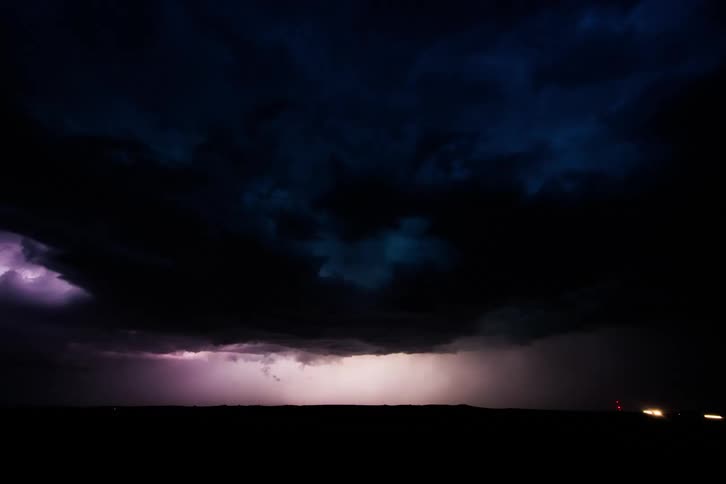 Cars driving during a thunderstorm at night