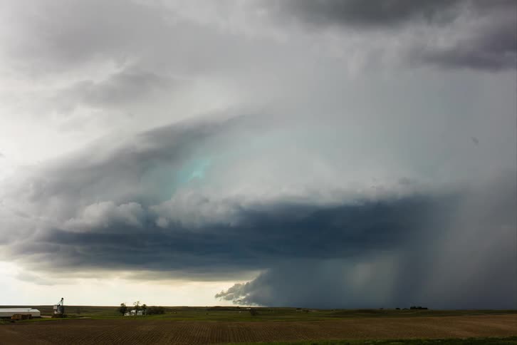 A storm cloud formation brings heavy rain over the plains