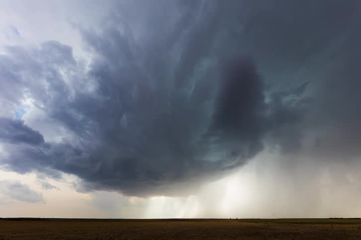Storm clouds move across the sky and pour rain down on the ground