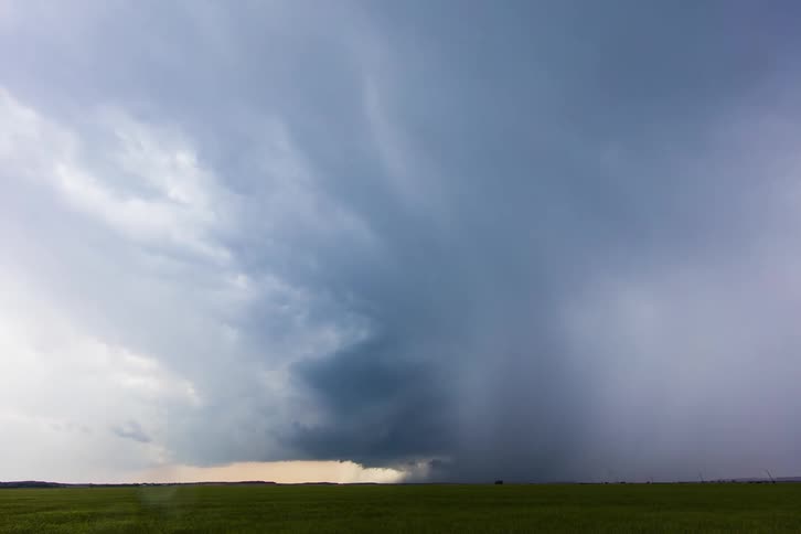 Storm clouds move in rotation across the ground and pour down rain