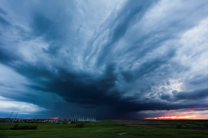 Dark stormy clouds gather in the sky at sunset casting a dramatic and ominous silhouette over the horizon
