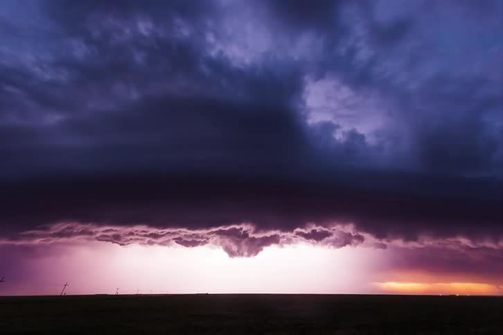 Time lapse of a thunderstorm and lightning rolling across a field