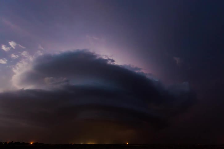 A thunderstorm in a rural field at dusk