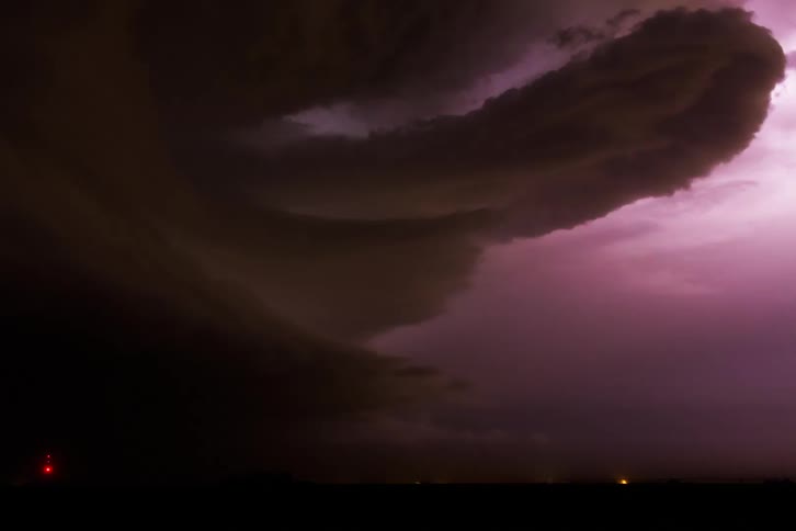 A hurricane of dark clouds with thunder lighting up the night