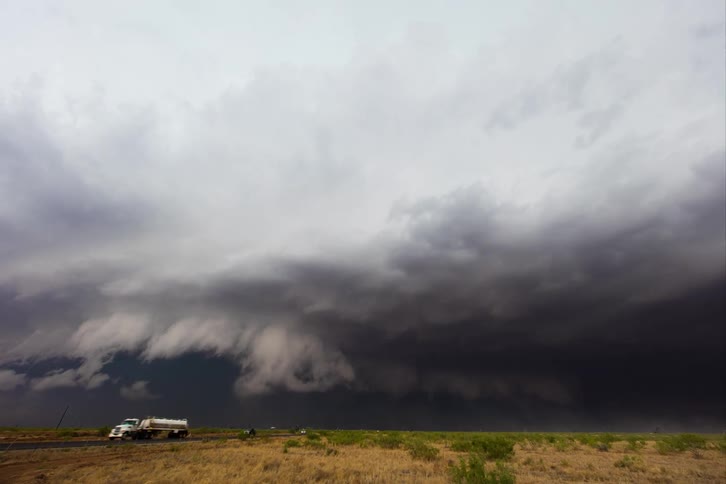 A tornado approaches rural areas during the day