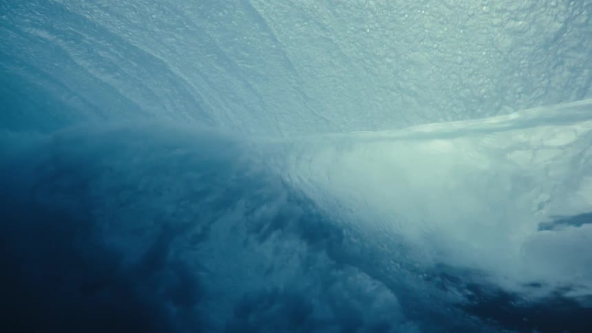 An underwater view of a sea wave breaking on the surface and making an inward wave