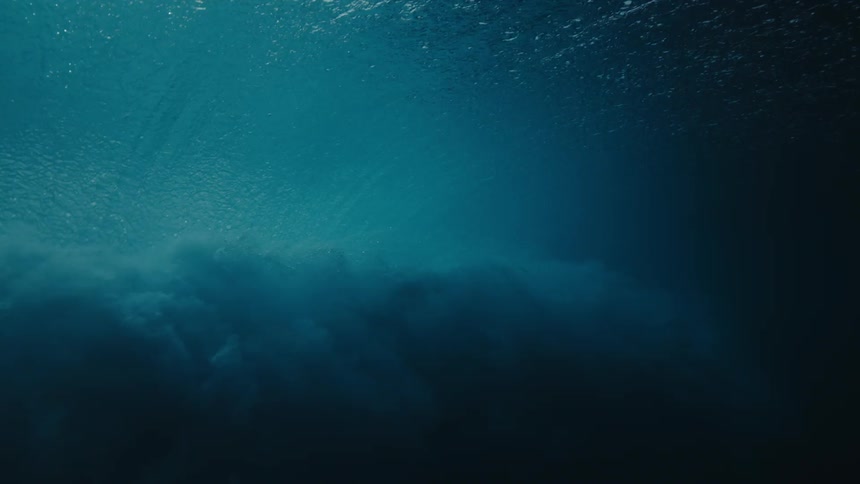 A water wave surges across the sea displaying the raw power and rhythmic beauty of the oceans movement