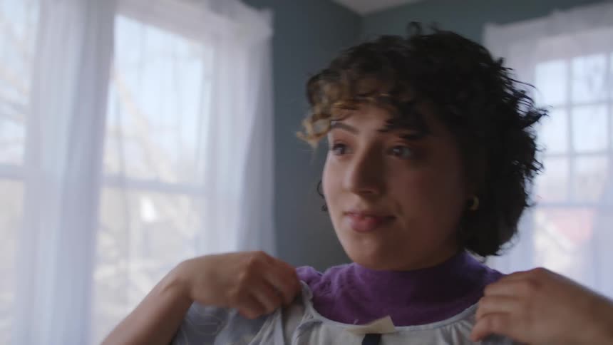 Woman trying clothes in the bedroom finds a dress she likes