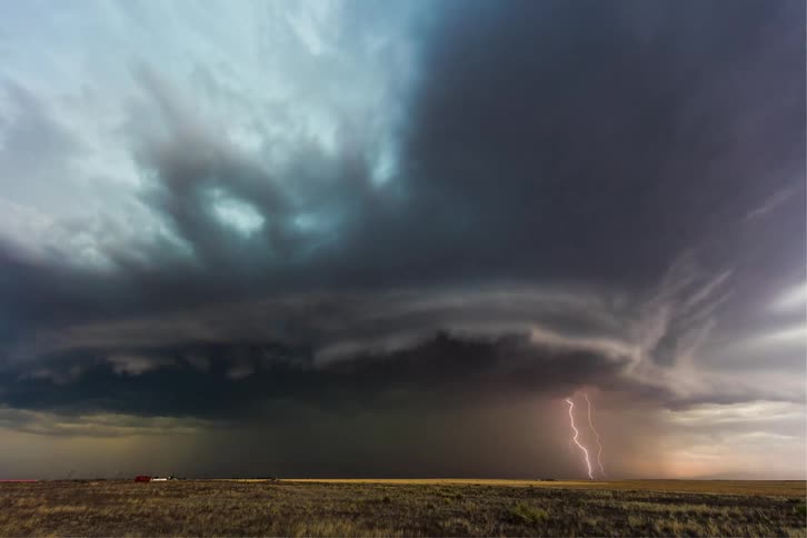 Time lapse lightening storm with rolling clouds over a rural prairie