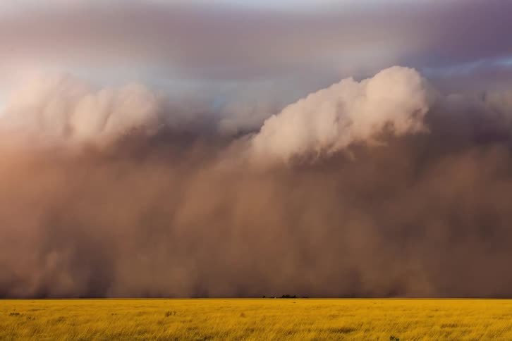 Huge dust storm moves across a rural landscape