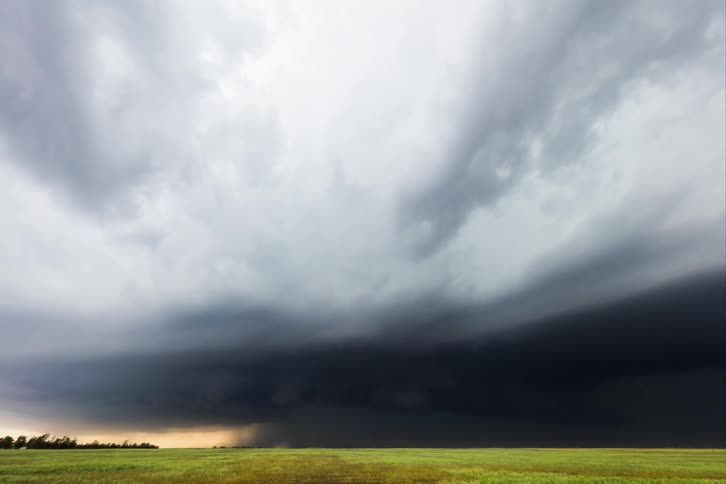 A tornado of dark clouds in a rural field