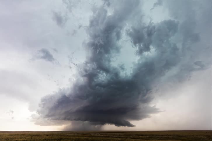 Storm clouds rolling and swirling over flat farmland