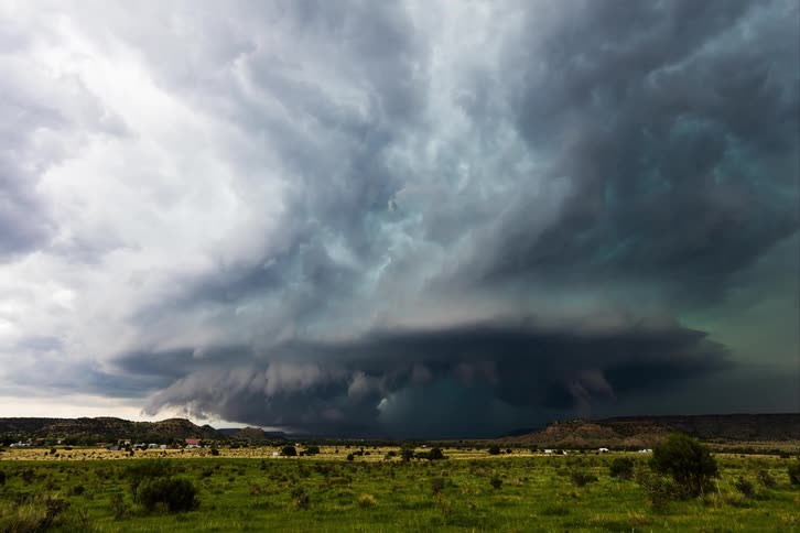 A tornado with lightning approaches a rural town