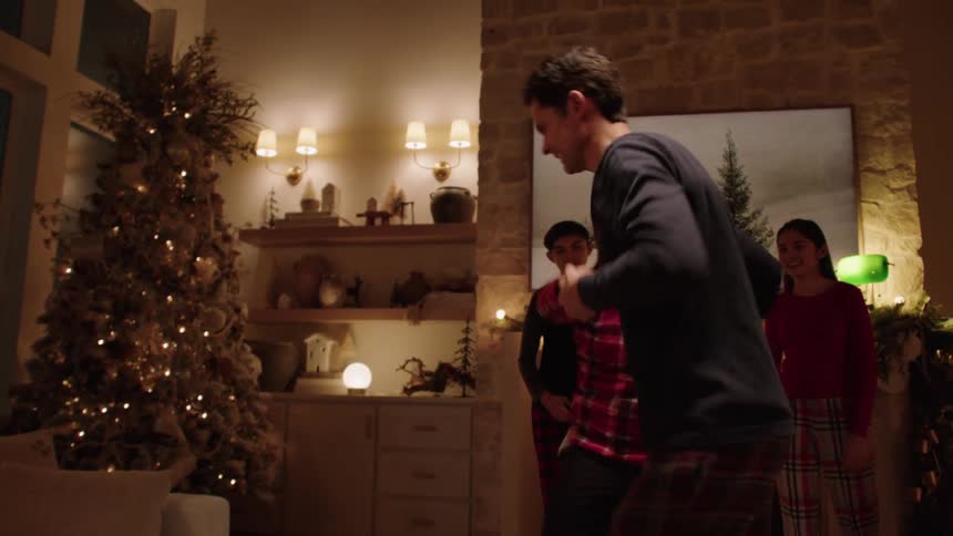 During the night children watch their parents dance in room decorated for christmas