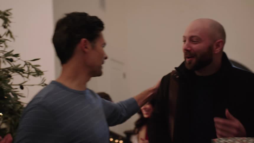 Family greeting each other and handing out christmas gifts