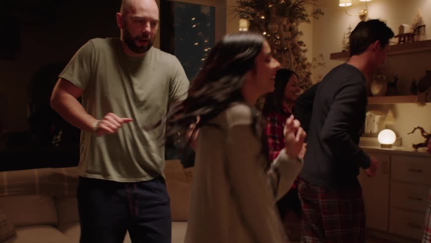 Adults and children dancing and smiling indoor at night