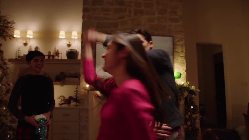 A happy family dancing in the living room at christmas