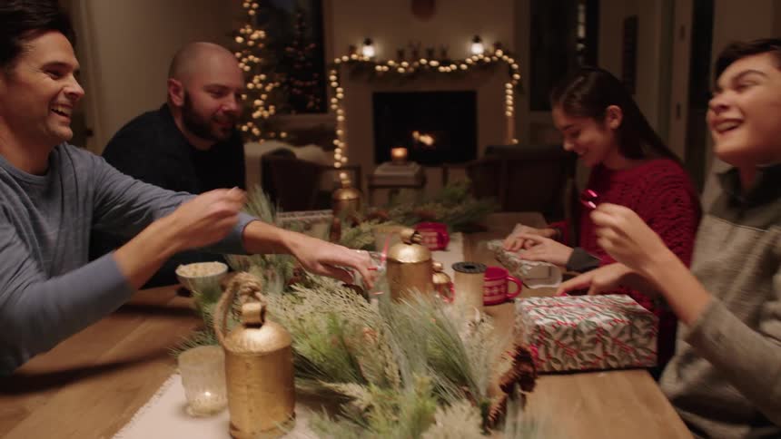 People seated at the dining table talking and smiling at night