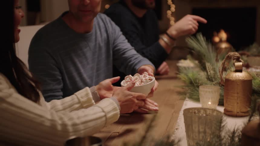 A family gathered at the table decorating for christmas