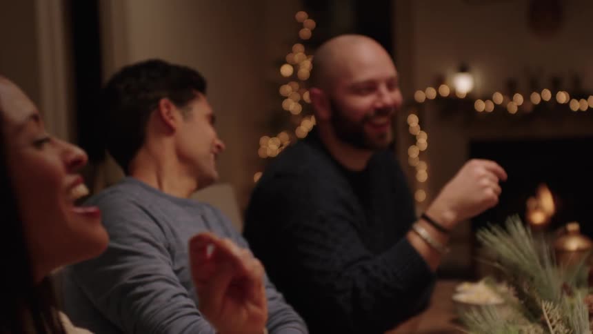 Family sitting at a christmas table playing and talking