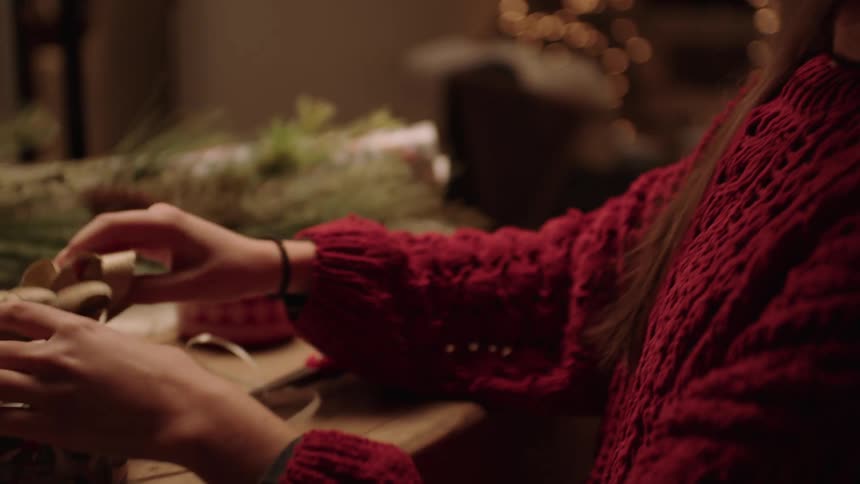 A smiling woman making christmas decorations
