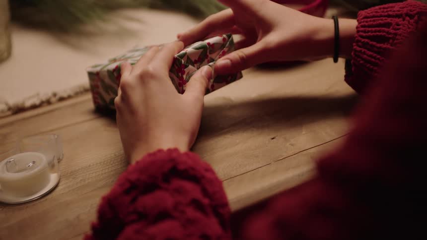 A person is wrapping a christmas gift