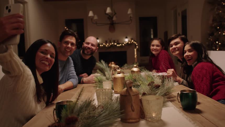 Family gathered around the table at christmas takes a selfie