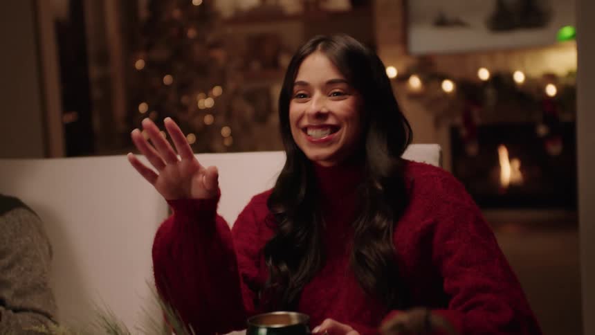 Happy woman wearing a red sweater talks and laughs