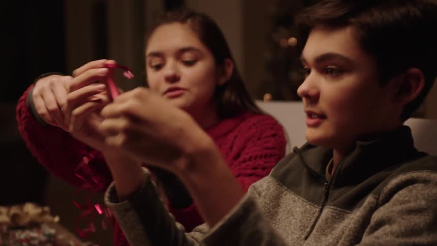 Siblings wrapping christmas gifts together