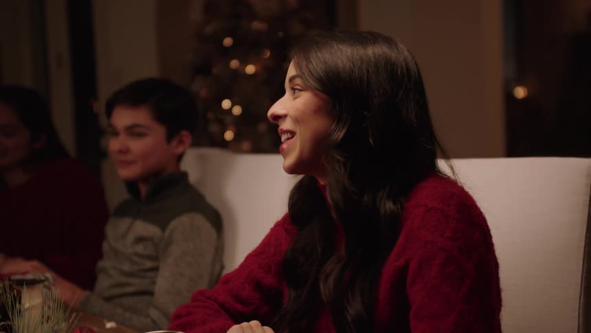 Brother and sister have a fun chat with the family at christmas dinner