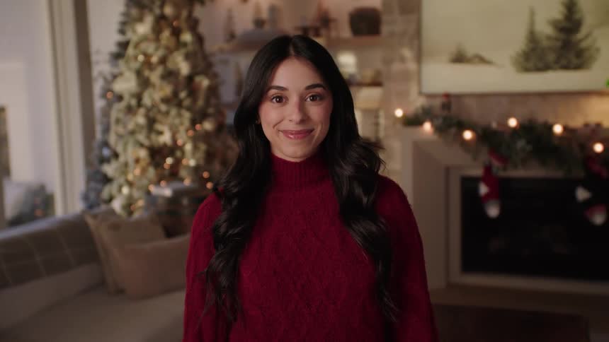 Portrait of a woman in a red sweater in a Christmas decorated living room