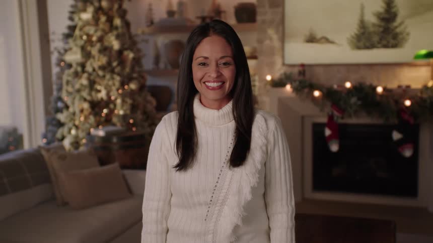 A woman standing in a living room and smiling