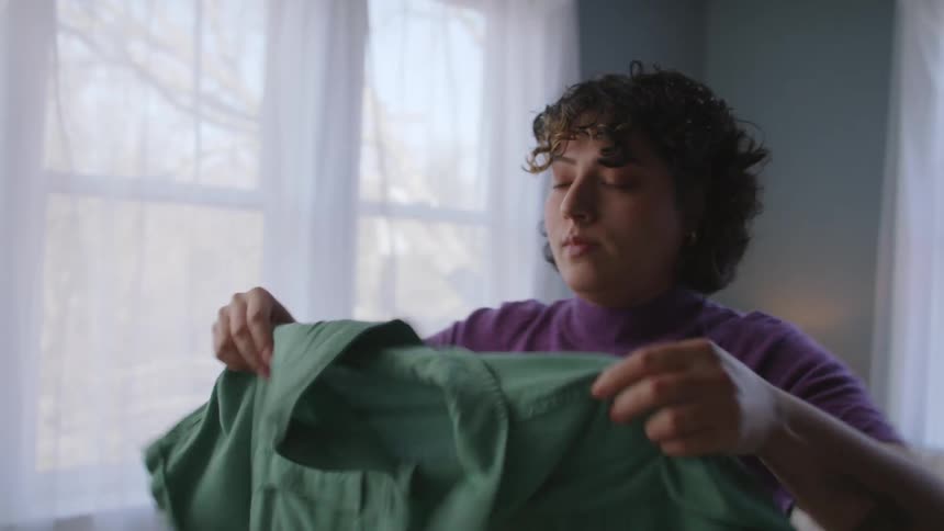 A woman is looking at different clothing to wear