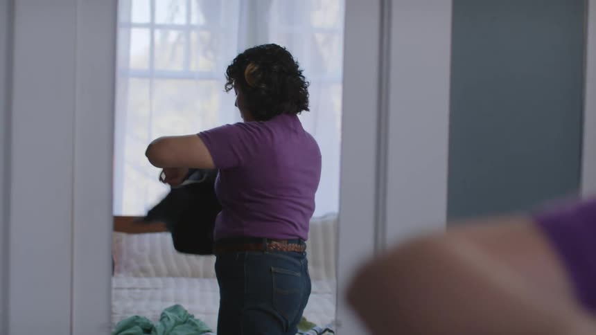 A clip of a woman testing different dress in the mirror
