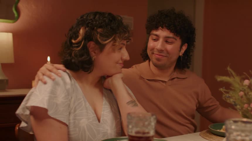 Young happy couple share a tender moment at dinner