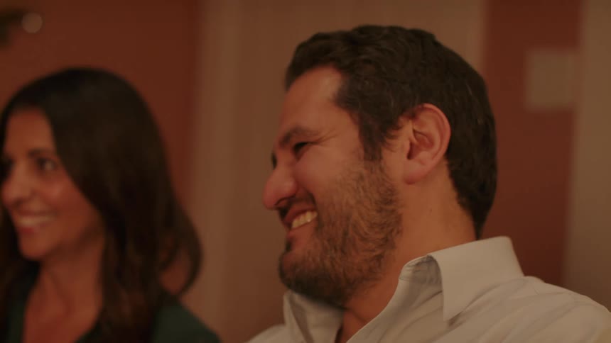 Man sitting in the living room laughs and smiles