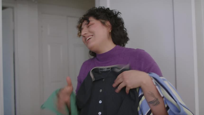 Woman selecting clothes in a hurry at hometion