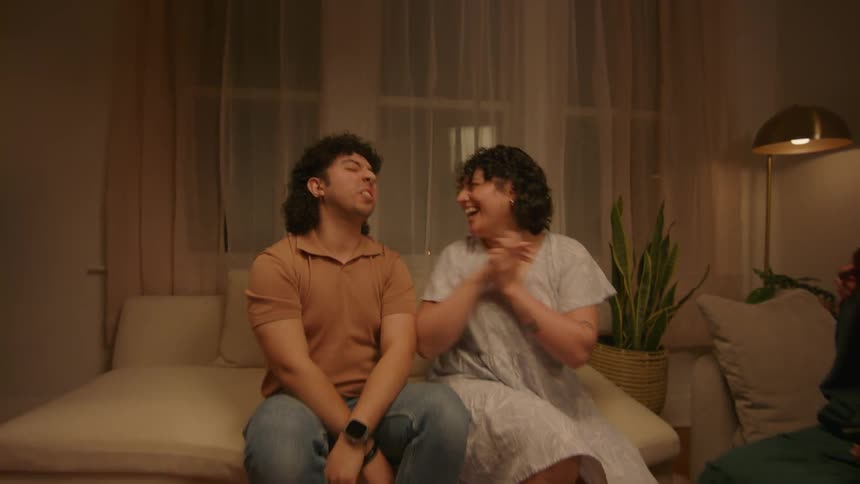 A mom playfully holds a photo album and her son is embarrassed