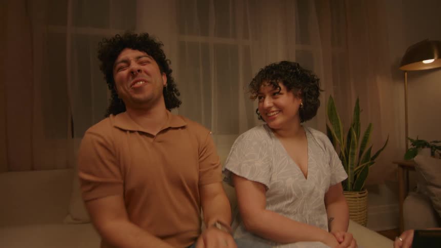 A young man is embarrassed by a photo that his parents show his girlfriend